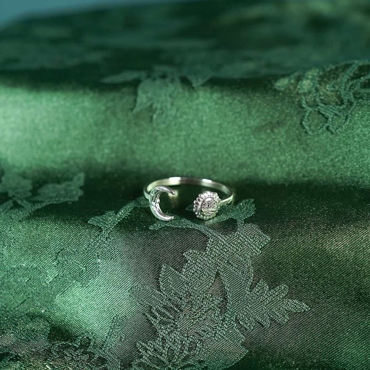 Silver adjustable ring with sun and moon design on silk