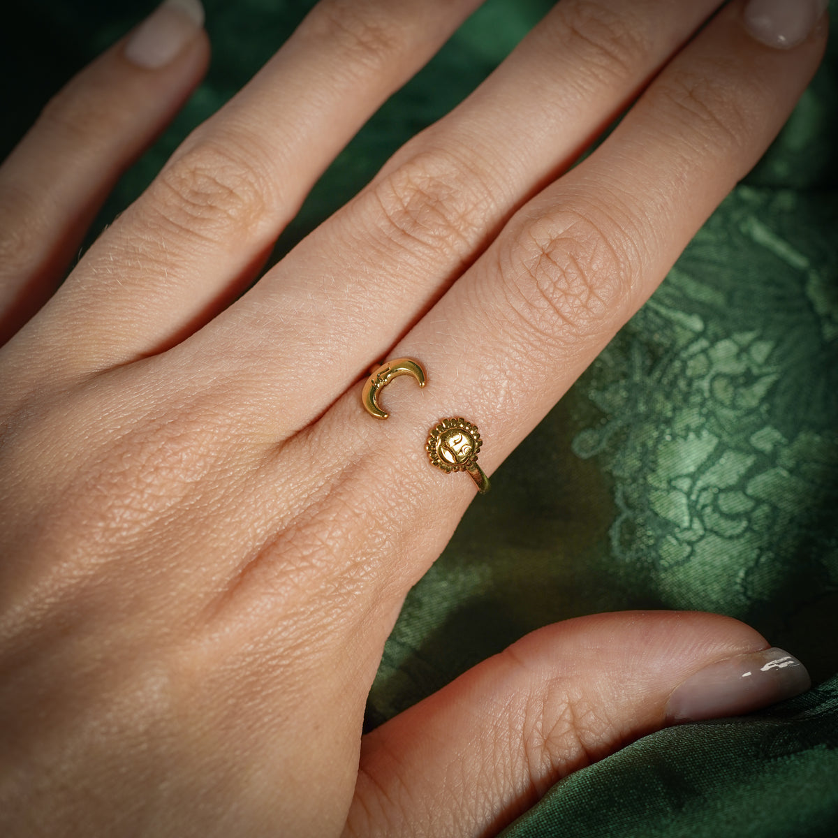 Gold adjustable ring with sun and moon design on hand