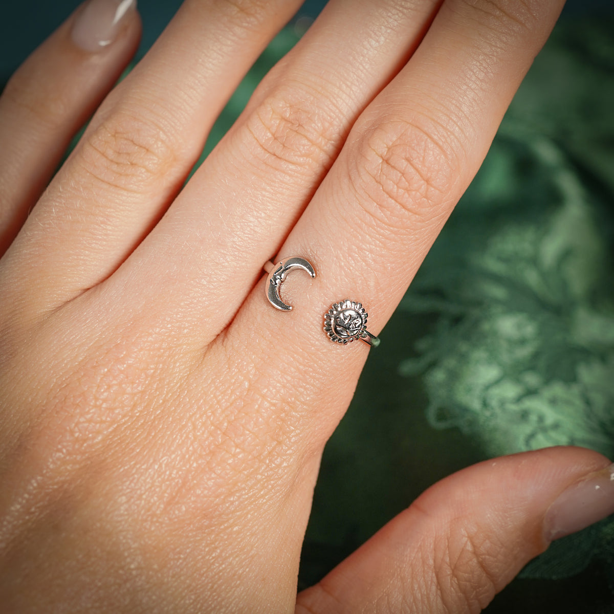 Silver adjustable ring with sun and moon design on hand