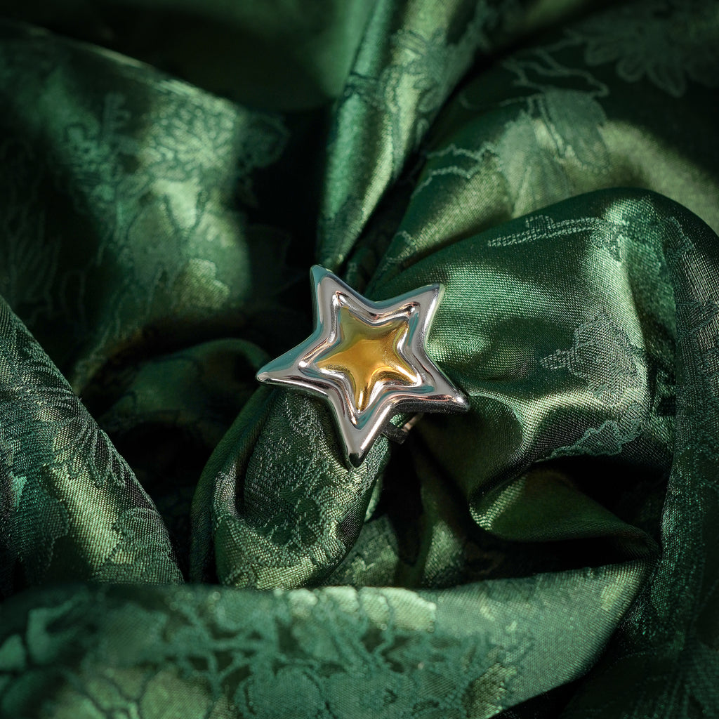 Chunky adjustable star ring on silk close up