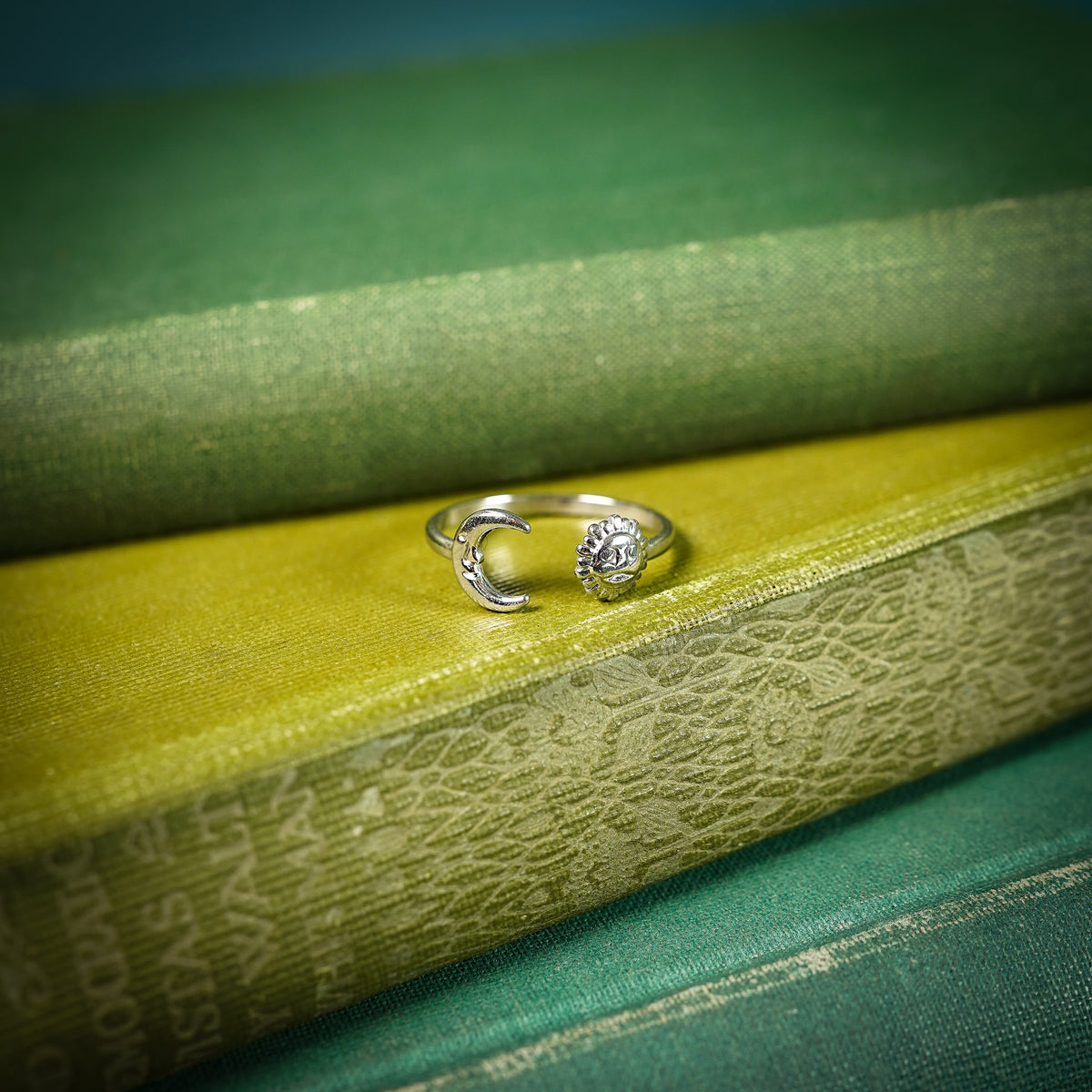 Silver adjustable ring with sun and moon design on book